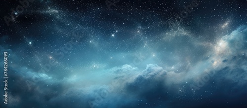 This image features a close-up view of the sky at night, showing stars twinkling amidst soft clouds