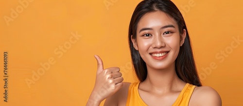 An assertive woman wearing a yellow sleeveless top is pointing directly at the viewer