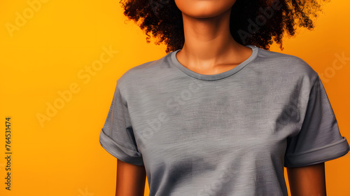Mock up a faceless woman wearing a grey T-shirt against a vibrant orange background, creating a minimalist and captivating composition
