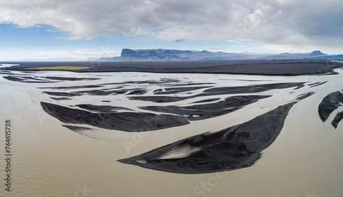 A braiding glacial river creates graphical patterns in volcanic debris on the vast glacial outwash plain Skeiðarársandur in front of the terminus of the Vatnajökull glacier