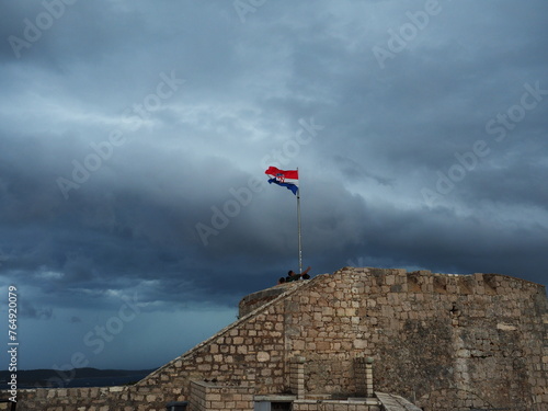 雨雲が迫るフヴァル城塞にはためく国旗