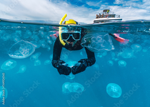 A woman is swimming in the ocean with jellyfish split shot
