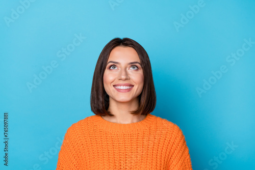 Portrait of attractive curious cheerful brown-haired girl looking up copy empty space clue isolated over bright blue color background