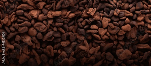 Capture the detailed view of a mound of roasted coffee beans in this image