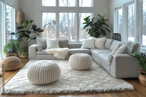 A spacious, snowy view through large windows complementing a modern white sofa and soft pouffes in a clean living room.