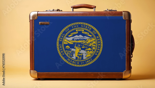 Nebraska flag on old vintage leather suitcase with national concept. Retro brown luggage with copy space text.