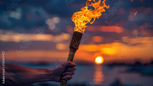 Close-up of a lighted Olympic torch at sunset