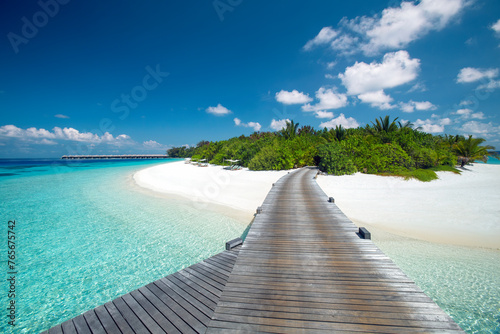 Wooden jetty leading to a tropical island with white sandy beach