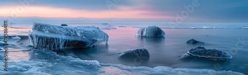 Ice-covered rocks rest on the surface of a body of water, creating a stark contrast between the frozen formations and the liquid underneath