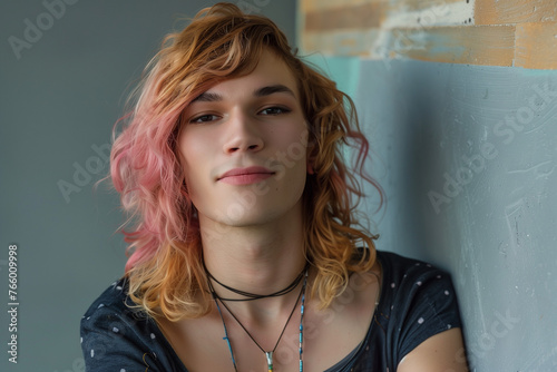 Transsexual woman, a person with gender transition from male to female with dyed hair and on a wall with a gay pride attitude