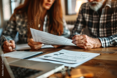 Elderly couple, old lady and man sitting together with a laptop and documents, discussing pension retirement plans, insurance, financial planning or vacation for seniors. 