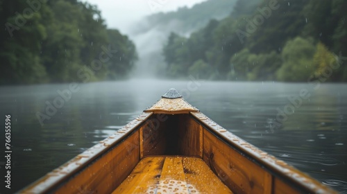 Rainy Canoe Journey on a Misty Forest Lake Gentle rain falls upon a wooden canoe, navigating through the misty embrace of a serene forest-lined lake.