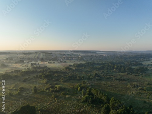 Łąki o brzasku, poranek w zamglonej zielonej okolicy, pastwiska oraz łąki o poranku, wschód słońca nad mokradłami, 