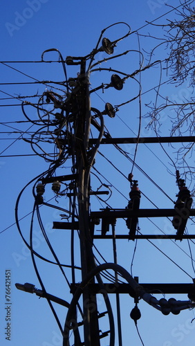 Poteau éléctrique avec un grand nombre effarant de fils électriques pendouillant dans les airs, partant dans toutes les directions, mauvaise organisation, branchement typique des pays pauvres emergent