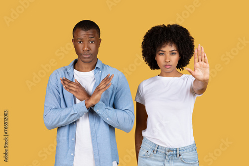 Serious African American man and woman making stop gestures with their hands