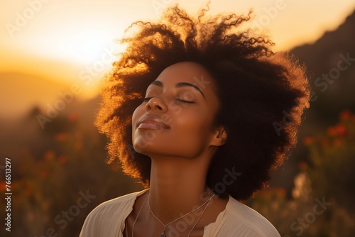 Retrato en primer plano de hermosa mujer negra respirando aire fresco durante un hermoso atardecer. Calma y relajación.