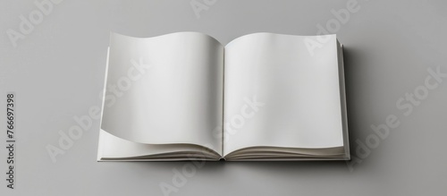 Design concept showing a white notebook from a top view, with blank pages opened, turned, and flipped on a gray background for a mockup. The image is a real photograph, not a .