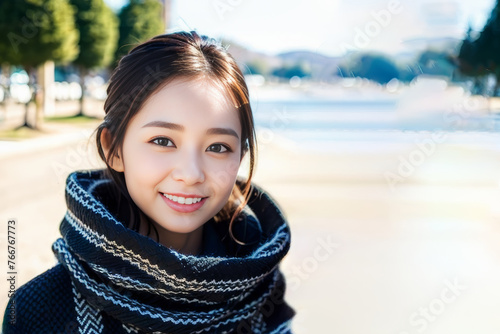 冬のデートでマフラーを巻いて笑顔でカメラ目線の日本人女性(モデル美女)