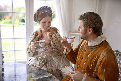 King, queen and couple with tea in castle, smile and conversation in vintage clothes with luxury at breakfast. Woman, man and drink together in morning with Victorian fashion at regal palace in UK