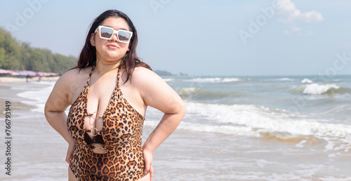 Portrait young asian woman fat chubby cute beautiful smile happy fun bikini swimwear body sexy front view tropical sea beach white sand clean and bluesky calm nature ocean wave water travel on holiday