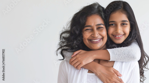 retrato de dos mujeres madre e hija hindúes sonriendo a cámara, la hija monta en caballito sobre su madre.