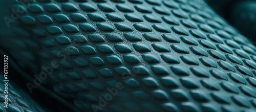 A closeup of an electric blue rubber mat with a mesh grille pattern and holes in it, creating a unique design in shades of azure and grey