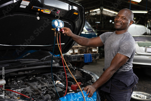 portrait mechanic worker fixing and checking a car air conditioning system in automobile repair shop