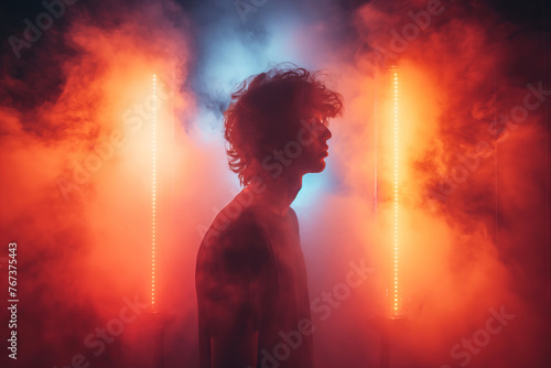Portrait of a young male hookah smoker vaper in a smoky atmosphere with neon light