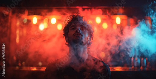portrait of man smoker smoking a smoky hookah in shisha bar with neon light