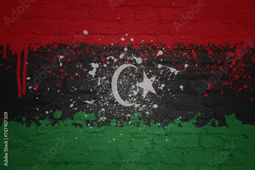 colorful painted big national flag of libya on a massive brick wall