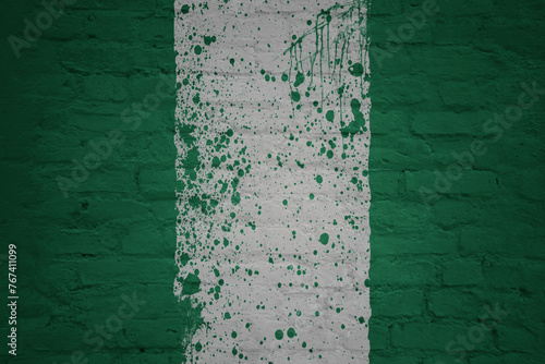 colorful painted big national flag of nigeria on a massive brick wall