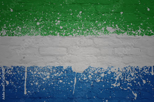 colorful painted big national flag of sierra leone on a massive brick wall