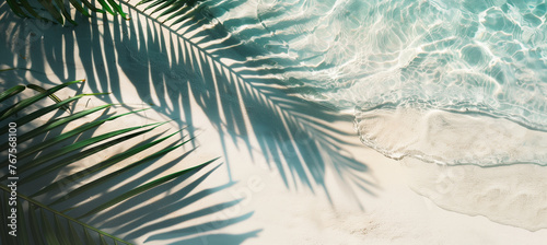 Tropical leaf shadows on the water surface and palm leaves on the white sand beach create a beautiful abstract summer vacation backdrop. Enhanced with blue translucent ice cubes. Presentation, makeup