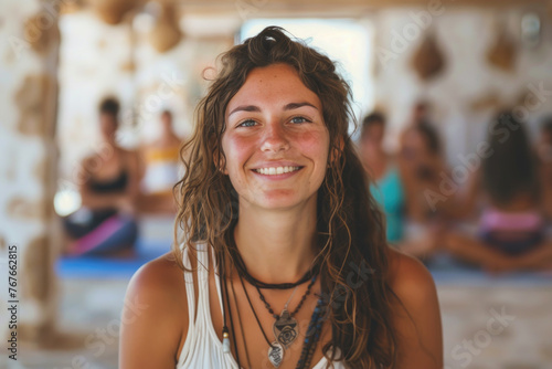 Portrait of a happy and smiling yoga teacher on Ibiza island, holding cacao drink in ceramic cup. Blurred people in the background