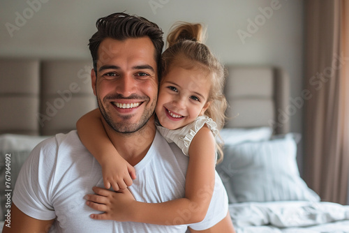 Latin man and his little daughter hugging in bedroom