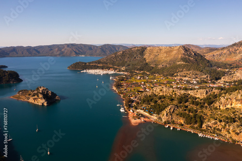 Aerial view of boats and beautiful city in Marmaris, Turkey. Landscape with boats in marina bay, sea, city lights, mountains. Top view from drone. 