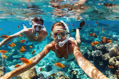 A youthful couple snorkeling in clear waters among vibrant fish, capturing the essence of marine discovery and adventure