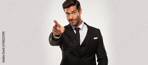 A professional man in a suit and tie is gesturing towards the camera in a confident manner