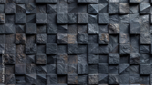 A black and gray stone wall with a rough texture. The wall is made up of many small square blocks