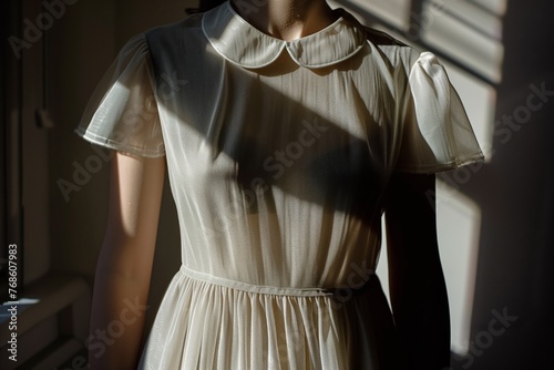 sunlight casting shadow on a dress with a peter pan collar