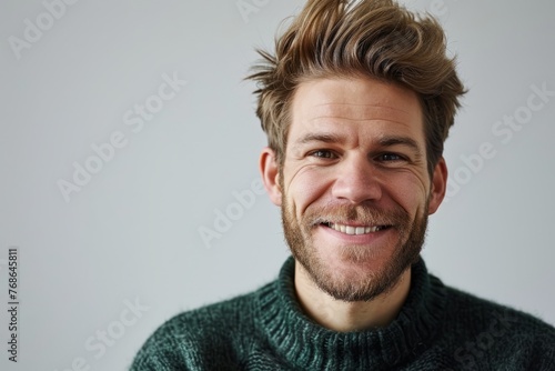 Portrait of a handsome man with a beard and mustache wearing a green sweater