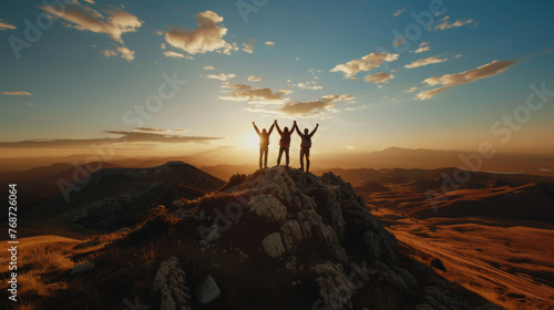 Together overcoming obstacles with three people holding hands up in the air on mountain top , 