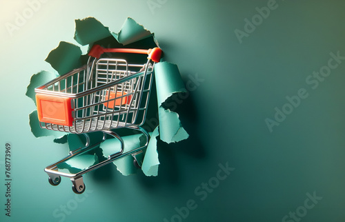 shopping cart ejaculated from through a torn green paper