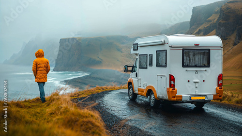 Camper driver next to his parked vehicle looks at the Icelandic landscape