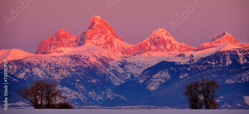 Teton Mountain Range Idaho Side Sunset Alpen Glow in Winter Blue Sky and Forest