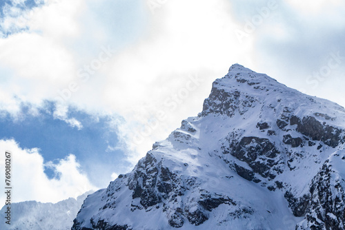 ostry szczyt Kościelec w Tatrach Polskich zimą na tle chmur