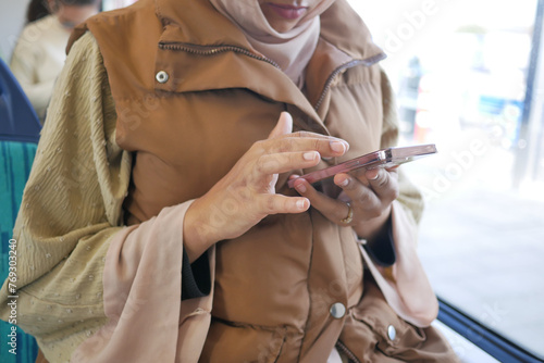 young women using smart phone inside of metro train 