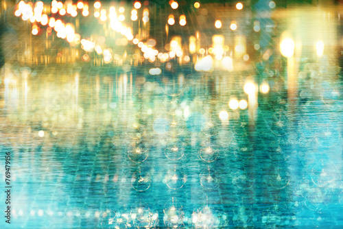 blur light of bar or pub reflection on blue water swimming pool summer party at night background