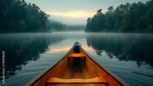 Canoe bow on a misty lake with forest backdrop, serene and tranquil morning.