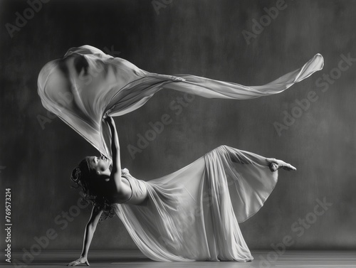 A monochrome image capturing the fluid motion of a dancer draped in flowing fabric, exemplifying elegance and dynamism.